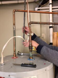 Corroded Magnesium anode rod being removed from a water heater