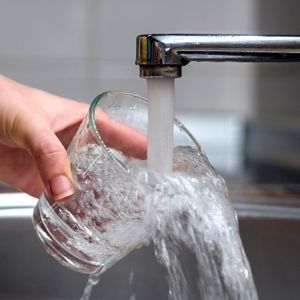 National Water Service water spilling out of a glass to signify that tankless water heaters do not heat as much water