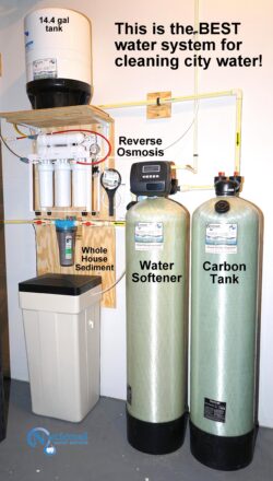 Photo of a water filtration system with labeled components: a 14.4-gallon tank, reverse osmosis system, whole house sediment filter, water softener, and carbon tank. Text reads: “This is the BEST water system for cleaning city water!”. Photo of a water filtration system with labeled components: a 14.4-gallon tank, reverse osmosis system, whole house sediment filter, water softener, and carbon tank. Text reads: “This is the BEST water system for cleaning city water!”.