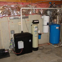 A Radon Reduction System with a pressure booster, a sediment filter, an acid neutralizer, a pressure tank and a hot water heater
