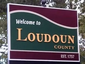 A sign reads Welcome to Loudoun County in large yellow letters, with EST. 1757 at the bottom right, set against a maroon and green background. Trees are visible behind, reflecting the natural beauty of an area known for water treatment Loudoun County VA.
